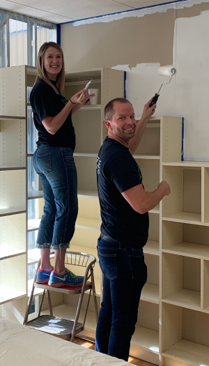 Photo of two people painting a wall