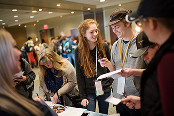 Photo of students filling out paper work at a table