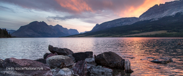 Photo of a lake at sunset with mountains in the background