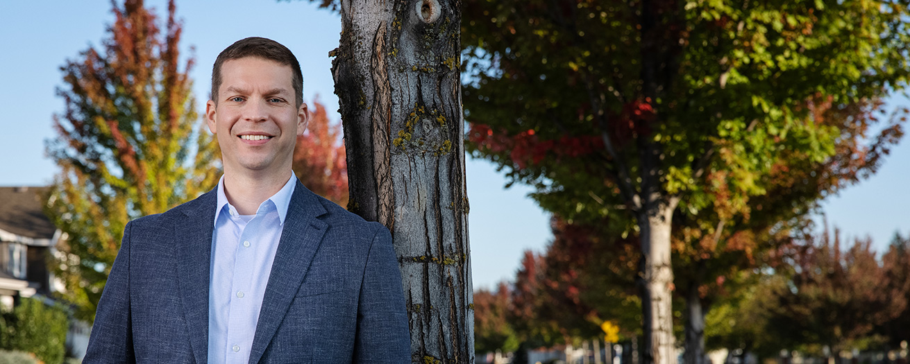 Photo of Nick Dotson standing next to a tree