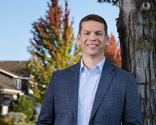 Photo of Nick Dotson standing next to a tree