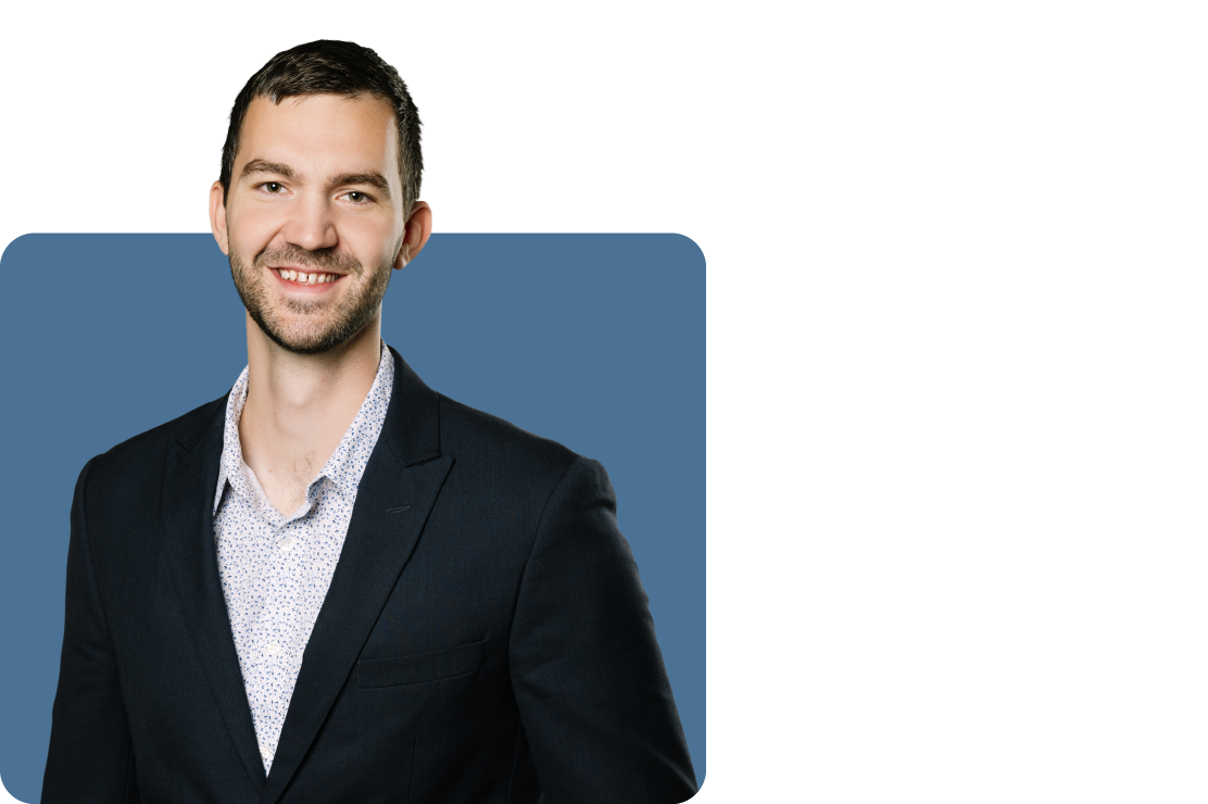 Headshot photo of Tyler Irish set against a blue backdrop